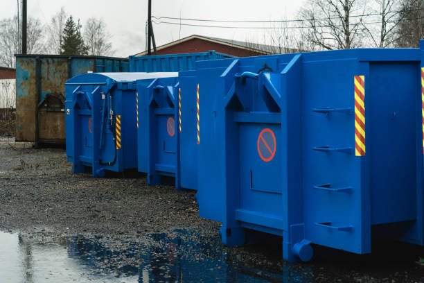large blue waste containers on gravel