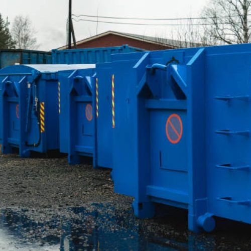 large blue waste containers on gravel
